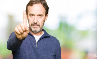 Orta yaş yakışıklı adam kazak giyiyor işaret parmağını ve kızgın ifade ile