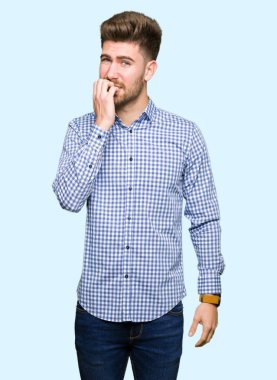 Genç yakışıklı bussines adam stresli ve gergin elle çivi ısırma ağzına bakan. Anksiyete sorunu.