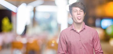 Genç yakışıklı iş adamı dilini izole arka plan üzerinde out komik ifade ile mutlu. Duygu kavramı.