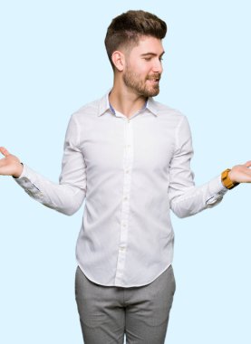 Genç yakışıklı iş adamı gülen gösteren her iki açık avuç içi, sunmak ve reklam karşılaştırma ve denge eller