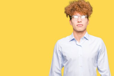 Genç yakışıklı iş adamı ile gevşek ciddi ifade ile yüzünde gözlüklü afro. Basit ve doğal kameraya bakıyor.