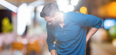 İzole genç yakışıklı adam arka plan geri el ile kas ağrısı dokunmadan acı sırt ağrısı,