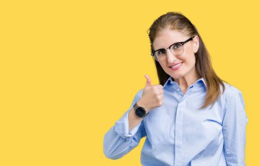 Güzel orta yaş olgun iş kadını mutlu yaşasın el ile jest yapıyor izole arka plan üzerinde gözlük takıyorum. Başarı gösteren kameraya bakarak ifade onaylama.