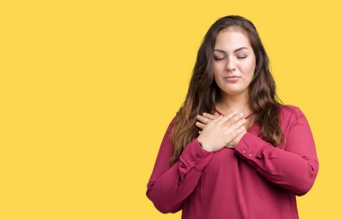 Güzel izole arka plan boyutu genç kadın artı ile gülümseyen gözlerin kapalı ve yüzünde minnettar jest ile göğüs üzerinde eller. Sağlık kavramı.