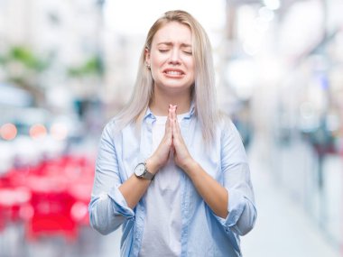 Genç Sarışın kadın dilencilik ve umut ifade yüzünde çok duygusal ve endişe ile birlikte elleriyle dua izole arka plan yüzünden. Bağışlanmak. Din kavramı.