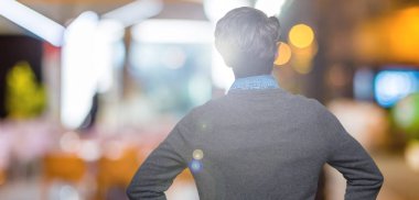 Genç yakışıklı zarif adam geriye doğru uzakta silah ile vücut üzerinde seyir ayakta izole arka plan üzerinde