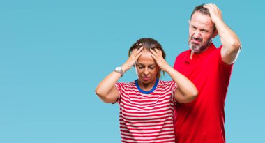 Orta yaş İspanyol çift aşık çünkü umutsuz ve stresli baş ağrısı acı izole arka plan üzerinde ağrı ve migren. Ellerini kafasına.