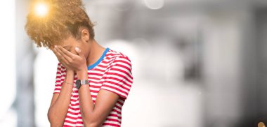 Güzel genç Afro-Amerikan kadın ağlayarak süre elleriyle yüzünü kapsayan üzgün ifade ile izole arka plan yüzünden. Depresyon kavramı.