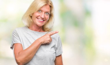 İzole arka neşeli bir gülümseme ile yüz el ve parmak kadar kameraya bakarak yüzündeki mutlu ve doğal ifade ile yan ile işaret orta yaş sarışın kadın.