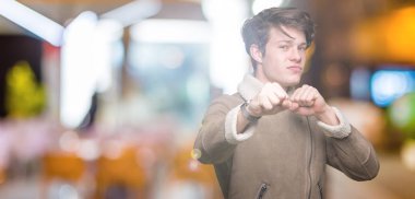 Yakışıklı delikanlı izole arka plan kum yumruk dövüşü, saldırgan ve kızgın saldırı, tehdit ve şiddet üzerine kış palto giyiyor