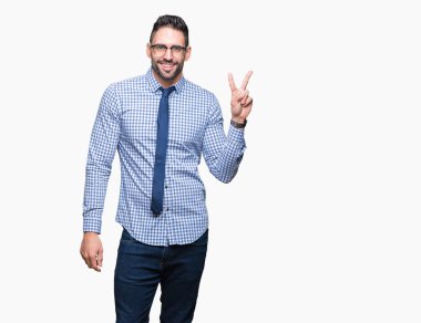 Mutlu yüz zafer işareti yaparken kameraya göz kırpıyor ile gülümseyen izole arka plan üzerinde gözlük takan genç iş adamı. İki numaralı.