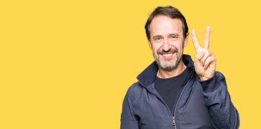 Orta yaş yakışıklı adam bir ceket gösterilen ve parmakları ile işaret ikincisi ise kendinden emin ve mutlu gülümseyerek.