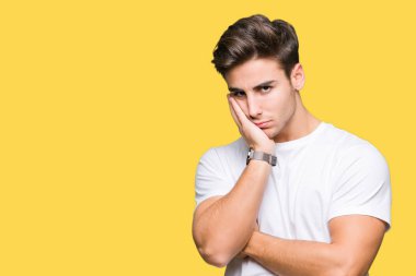 Seyir yorgun ve bıkkın ile depresyon sorun Çapraz kollar ile izole arka plan düşünme üzerinde beyaz t-shirt giyen genç yakışıklı adam.