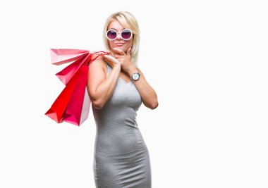 Genç güzel sarışın kadın Holding alışveriş torbaları satış üzerinden alışveriş arka plan ciddi bir yüz düşünme hakkında soru, çok karışık fikir izole