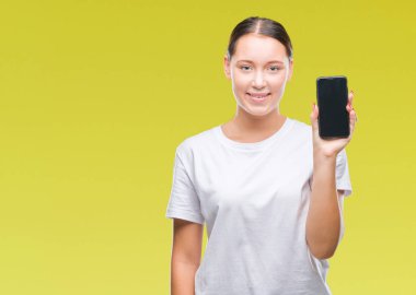 Genç güzel beyaz kadın gösteren smartphone ekran üzerinde duran ve diş gösterilen kendine güvenen bir gülümsemeyle gülümseyerek mutlu bir yüz ile izole arka plan