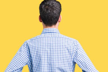 Genç yakışıklı iş adamı izole arka plan ayakta geriye doğru uzakta silah ile vücut üzerinde seyir üzerinde