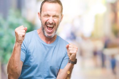 Gülümseyen ve başarı için çığlık orta yaş ağarmış üst düzey adam izole arka plan çok mutlu ve heyecanlı kaldırdı, silah ile kazanan jest yapıyor. Kutlama kavramı.