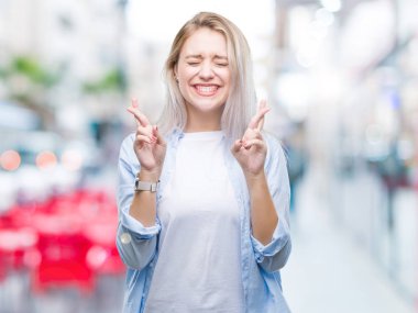 Genç Sarışın kadın geçiş parmakları umut ve gözler gülümseyen izole arka plan yüzünden kapalı. Şans ve batıl kavramı.