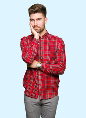 Yakışıklı delikanlı düşünme seyir yorgun ve sıkılmış çapraz silah depresyon sorunları ile.