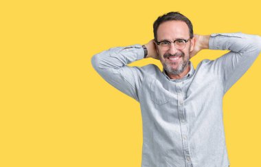 Yakışıklı orta yaş zarif komuta sizde gözlük izole üzerinde arka plan dinlenirken ve germe kollar ve eller baş ve boyun arkasında ile mutlu gülümseyerek