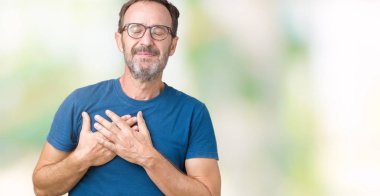 Göğüs kapalı gözler ve yüzünde minnettar jest ile gülümseyen izole arka plan üzerinde gözlük nedir yakışıklı orta yaş ağarmış komuta sizde eller. Sağlık kavramı.