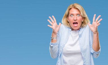 Orta yaş sarışın kadın deli kutluyor arka plan izole ve başarı için kaldırdı kollarını açarak hayrete ve heyecanlı çığlık gözleri açık. Kazanan kavramı