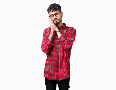 Uyku yorgun hayal ve ellerle birlikte poz ile kapalı gözler gülümseyen izole arka plan üzerinde gözlük takan genç yakışıklı adam.