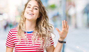 Gösterilen ve parmakları ile işaret izole arka plan üzerinde sarışın güzel genç kadın kendinden emin ve mutlu gülümseyerek süre beş numara.