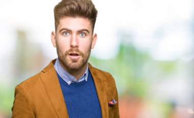 Genç yakışıklı iş adamı korkuyor ve sürpriz ifade, korku ve heyecan yüz ile şok.