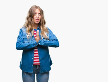 Güzel sarışın genç kadın dilencilik ve umut ifade yüzünde çok duygusal ve endişe ile birlikte elleriyle dua izole arka plan üzerinde. Bağışlanmak. Din kavramı.