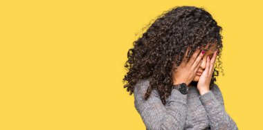 Kıvırcık saçlı giyen ile genç güzel kadın gri kazak üzgün ifadeyle yüz eller ile ağlayarak süre kapsayan. Depresyon kavramı.