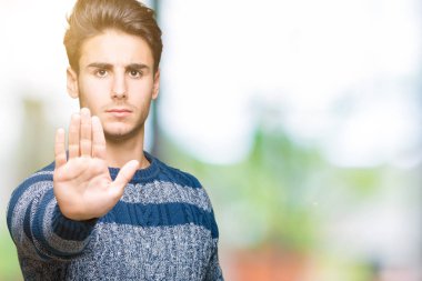 Yakışıklı delikanlı dur yapıyor izole arka plan üzerinde şarkı elin avuç ile. Negatif ve ciddi bir jest yüz ifadesiyle uyarı.