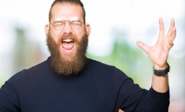 Gözlük ve kızgın ve silah ile başarı için deli kutluyor boğazlı kazak giyen genç sarışın adam kaldırdı ve heyecanlı çığlık gözler kapalı. Kazanan kavramı