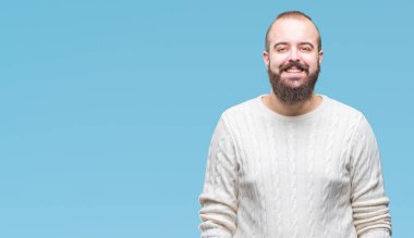 Yüzünde mutlu ve güzel bir gülümseme ile izole arka plan üzerinde kış kazak giyen genç beyaz hipster adam. Şanslı kişi.