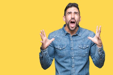 Genç yakışıklı adam izole arka plan çılgın ve kızgın bağırarak ve agresif ifade ve silah kaldırdı bağırıyor. Hayal kırıklığı kavramı.