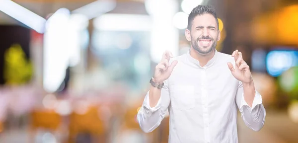 Joven Hombre Negocios Sobre Fondo Aislado Sonriendo Cruzando Los Dedos —  Fotos de Stock