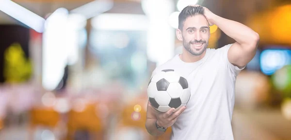 Joven Sosteniendo Pelota Fútbol Sobre Fondo Aislado Estresado Con Mano — Foto de Stock