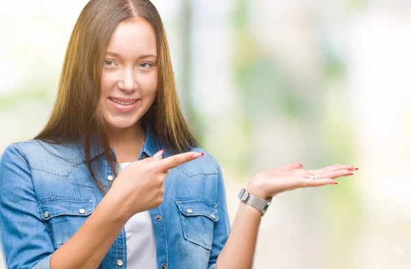 年轻的白种人美丽的女人在孤立的背景惊讶和微笑的相机 而提出与手和手指指向 — 图库照片