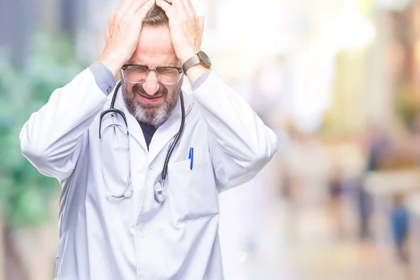 中年老年白发医生身穿医疗制服 孤立背景 因疼痛和偏头痛而受到压力 双手放在头上 — 图库照片