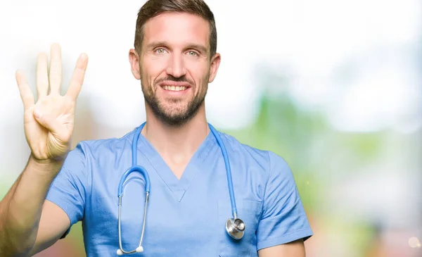 英俊的医生穿医疗制服在孤立的背景显示和手指第四 同时微笑着自信和快乐 — 图库照片
