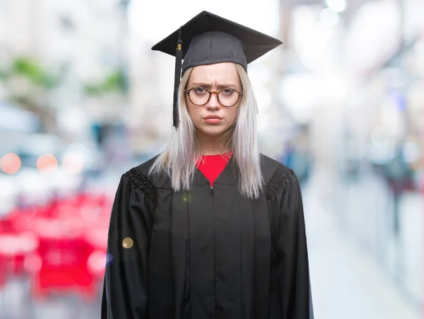 若いブロンドの女性の問題のため懐疑的な孤立した背景と神経質 しかめっ面の動揺を大学院の制服を着てします 否定的な人 — ストック写真