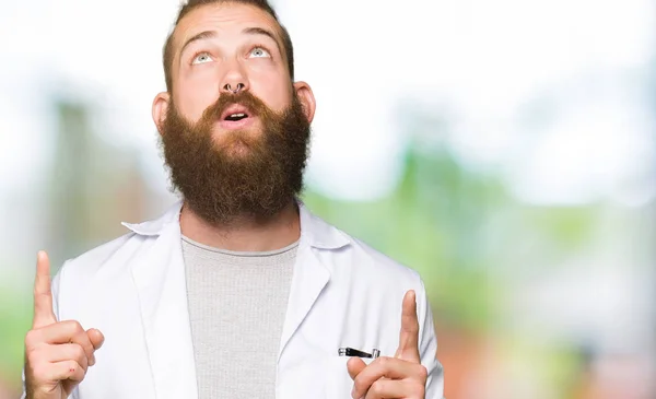 Ung Blond Forskare Man Klädd Vit Rock Förvånad Och Överraskad — Stockfoto