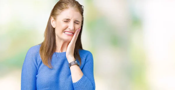 美しい中年熟女歯痛や歯の歯科病気のため痛みを伴う式で手で口に触れて分離の背景に冬のセーターを着ています 歯医者コンセプト — ストック写真