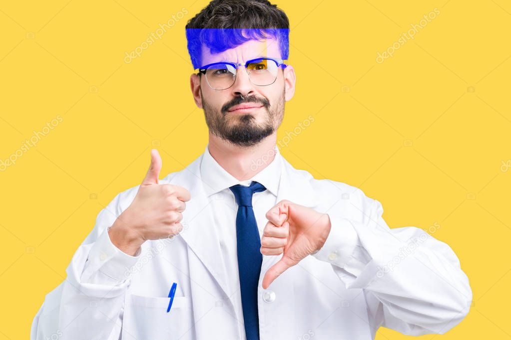 Young professional scientist man wearing white coat over isolated background Doing thumbs up and down, disagreement and agreement expression. Crazy conflict