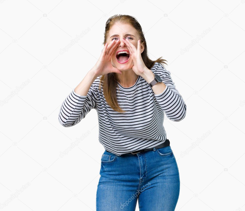 Middle age mature beautiful woman wearing stripes winter sweater over isolated background Shouting angry out loud with hands over mouth