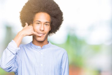 Afro saçlı yapıyor gülümseyen genç Afro-Amerikan adam telefon hareketi ile el ve parmak telefonda konuşuyor gibi. Kavramları iletişim.
