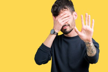 Genç yakışıklı adam izole elleriyle gözlerini kapsayan arka plan ve stop jest ile acı ve korku ifadesi. Utandım ve negatif kavramı.