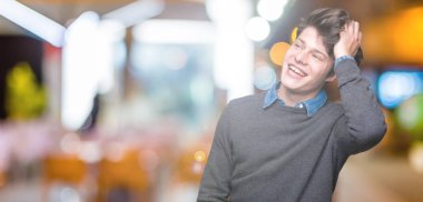 Genç yakışıklı zarif adam el jest yukarıya ile kendine güvenen dokunaklı saç gülümseyerek, çekici poz izole arka plan üzerinde