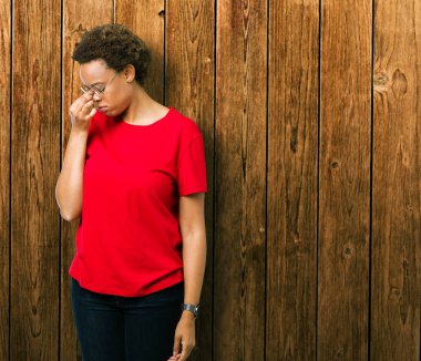 Güzel genç Afro-Amerikan kadın gözlük izole arka plan üzerinde sürtünme burun ve göz yorgunluğu ve baş ağrısı duygu yorgun. Stres ve hayal kırıklığı kavramı.