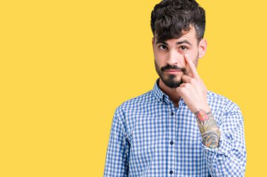Genç yakışıklı iş adamı izole üzerinde arka plan işaret jest göz izlemek için şüpheli ifade